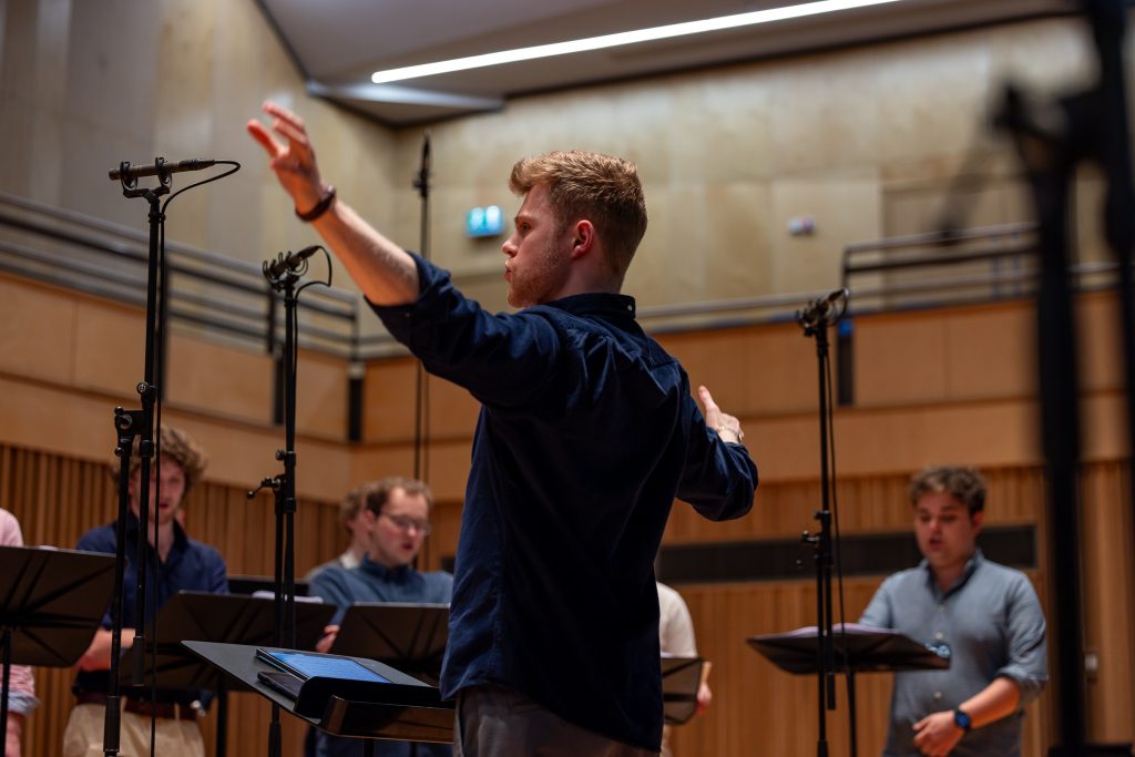 Adam Whitmore conducting an ensemble rehearsal with musicians